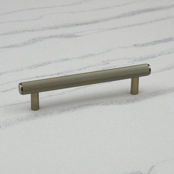 An antique brass reeded T-bar handle 