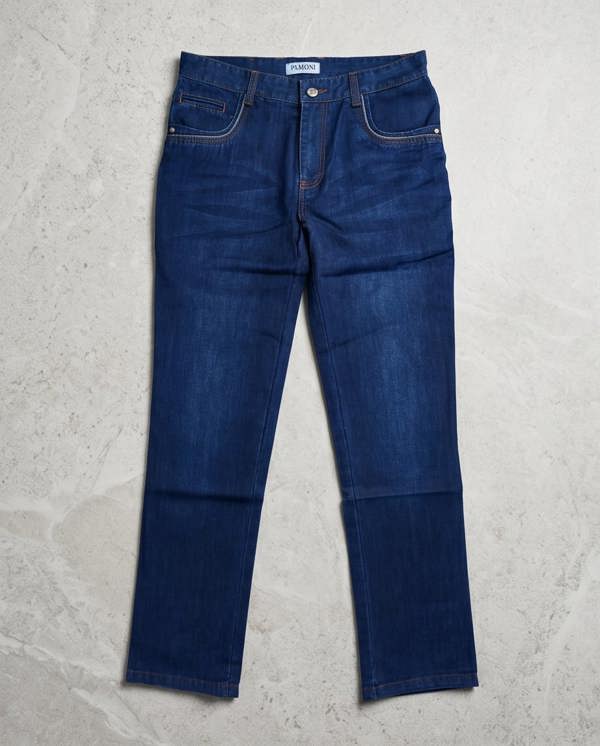 Pair of blue jeans on a light gray surface