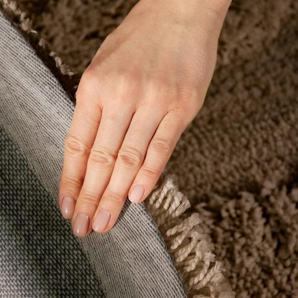 Close-up of a hand resting on a textured surface