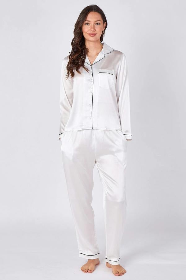 Woman wearing a white satin pajama set on a plain background
