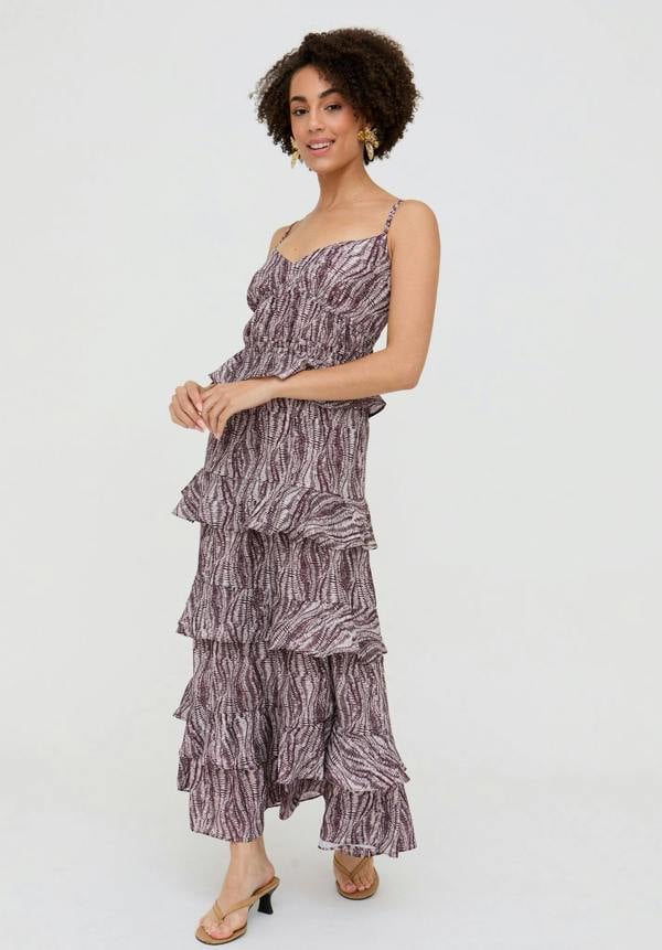 Woman wearing a tiered dress with a zebra print pattern on a white background