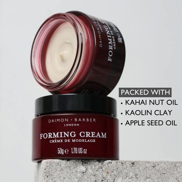Open jar of Forming Cream on top of another with ingredients listed on grey background.