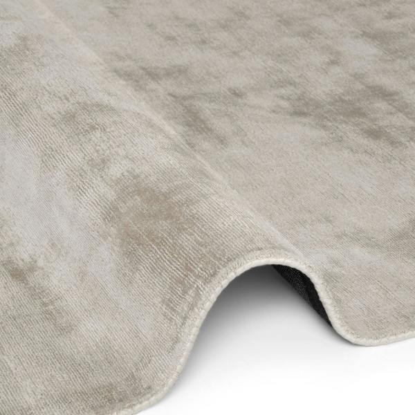 Close-up of a textured gray rug corner on a white background