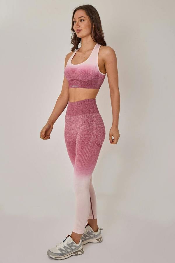 Woman wearing a pink athletic outfit on a plain background
