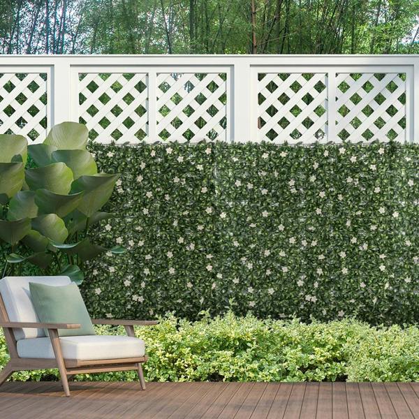 Green artificial privacy screen with dense faux hedge leaves and white rhododendron flowers