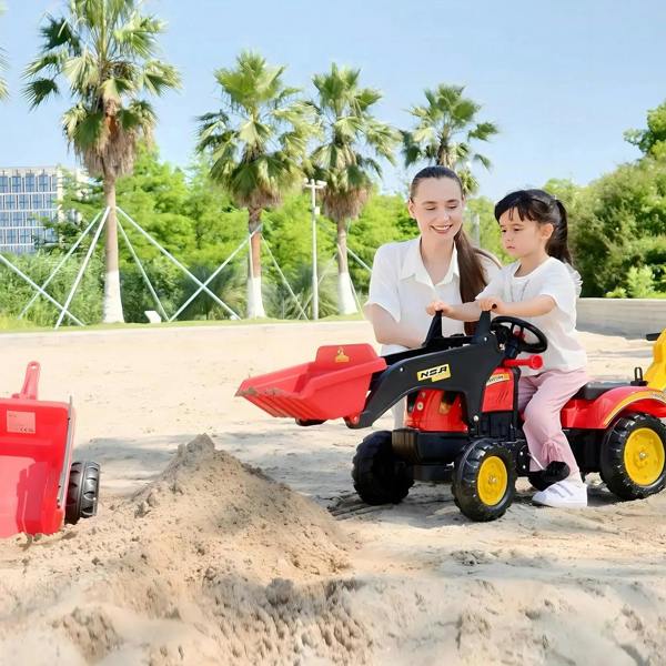 Red and yellow kids pedal excavator ride-on toy being driven in sand with bucket raised