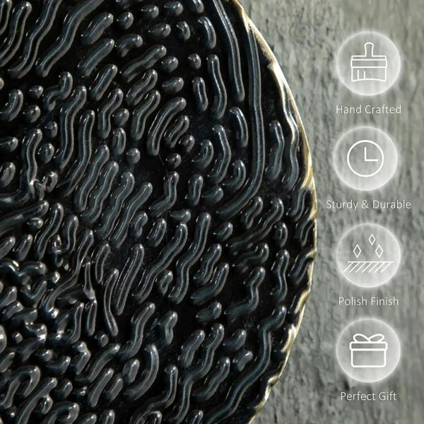 Close-up of textured black metal disc with glossy highlights and gold-toned edge
