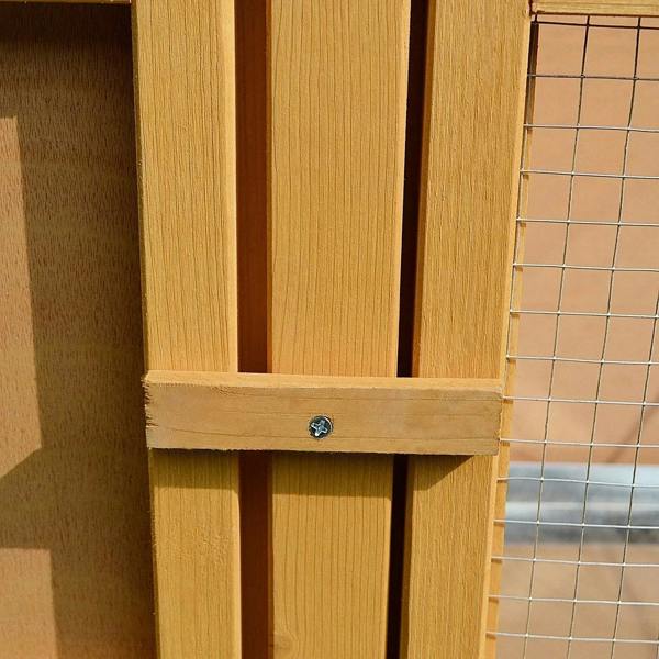 Wooden hutch door latch with metal fastener on wire panel section