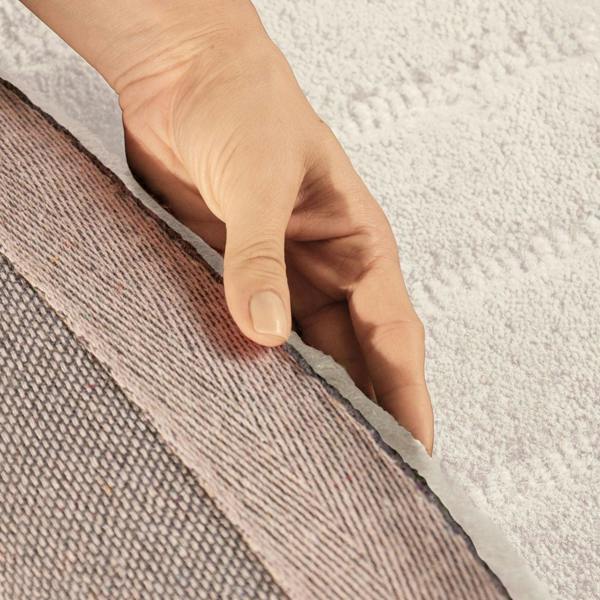 Hand touching the edge of a textured fabric surface