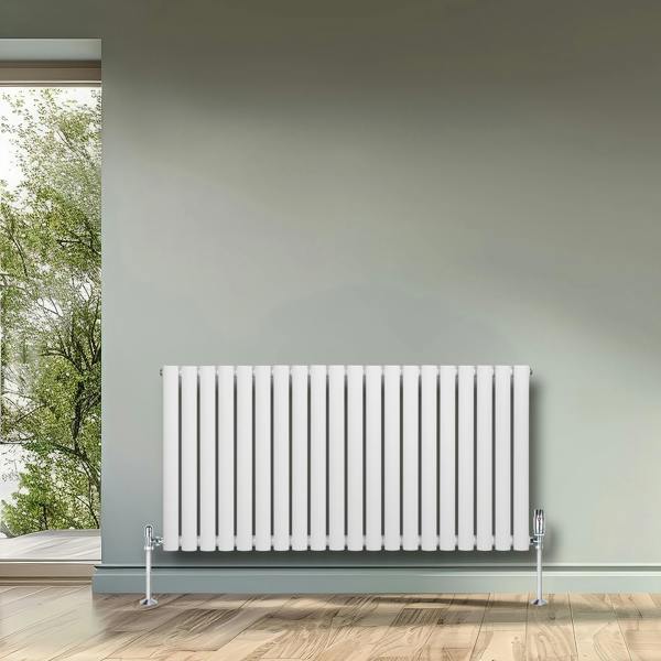 White oval single column radiator, 600 x 1200mm, featuring sleek vertical lines, mounted against a soft green wall in a bright room