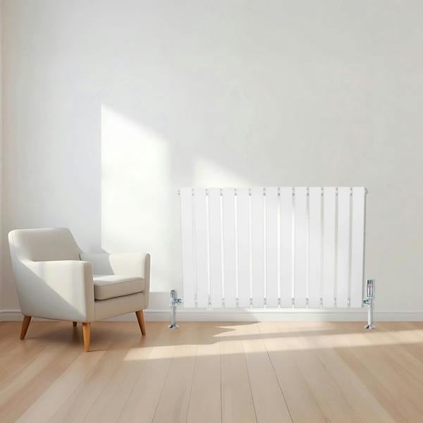Flat single column radiator in white, 600 x 910mm, sleek design with vertical slats, positioned beside a modern armchair in a bright room