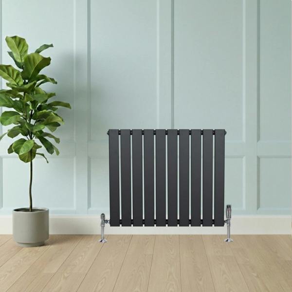 Flat single column radiator in anthracite grey, featuring a sleek design with vertical slats, positioned against a light blue wall and wooden floor