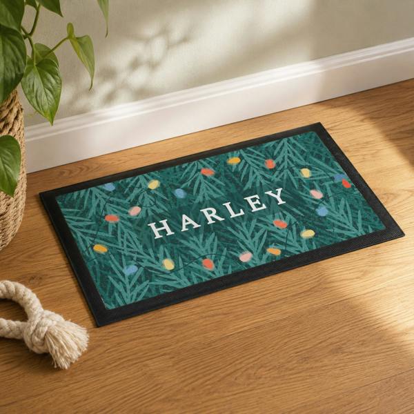 Personalised Christmas pet bowl mat featuring a retro fairy light and pine tree pattern with the name HARLEY.