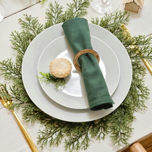 Set of Four Evergreen Foliage Place Mats styled with a white plate and green napkin on a rustic table.