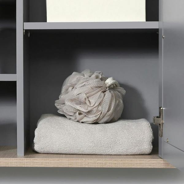 Grey wall mirror cabinet interior with folded towel on lower shelf