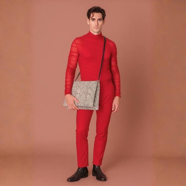 Model is wearing a red top and trousers and  a snake print quilted laptop clutch bag with chain strap. Plain Background