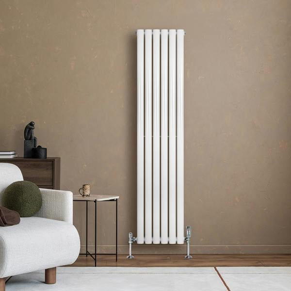 Sleek white oval single column radiator with valves, standing tall against a textured brown wall, enhancing modern interior decor