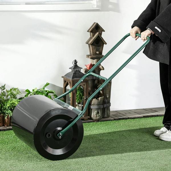 Black lawn roller drum with green frame and handle for flattening grass areas