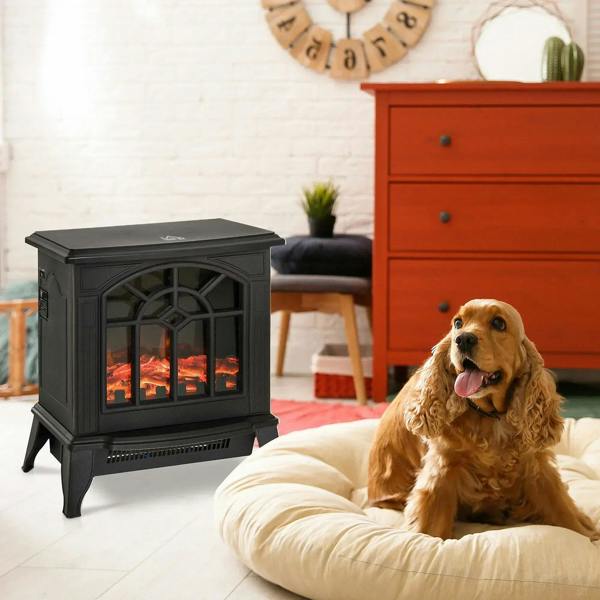 Black freestanding electric fireplace stove with LED flame effect next to a dog on a bed.