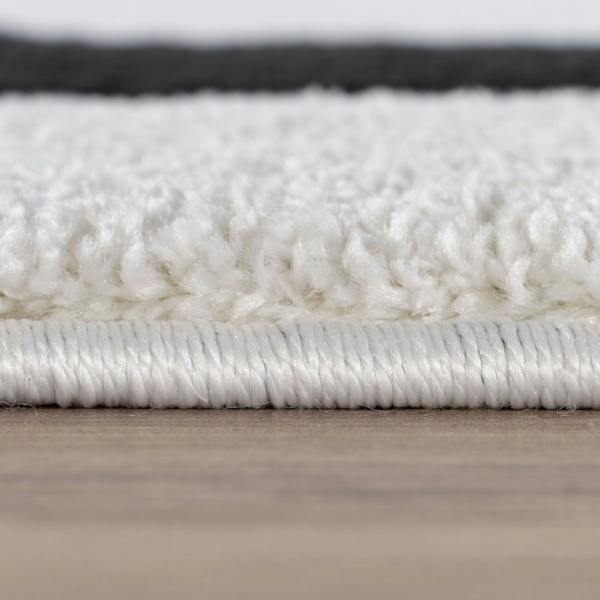 Close-up of a white textured rug on a wooden floor