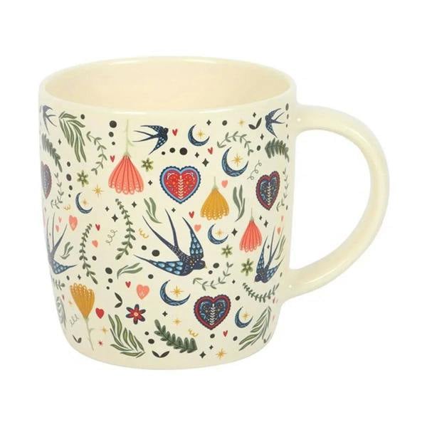 Cream mug with colorful bird, hanging lantern, and heart print
