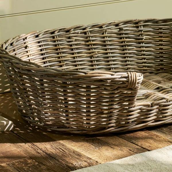 Close-up of the grey handwoven rattan weave and sturdy front lip of the pet bed.