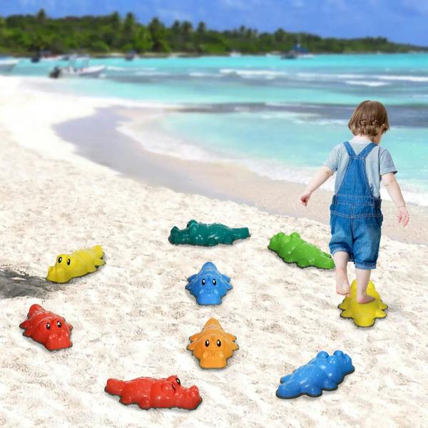 Kids stepping on colorful crocodile stepping stones on a sandy beach