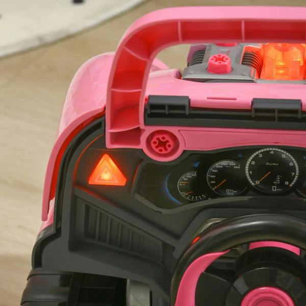Pink toy truck with open hood showing steering wheel, gauges, and glowing hazard light.
