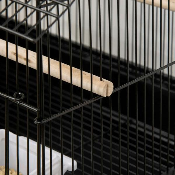 Black metal bird cage close-up with wooden perch and vertical bars