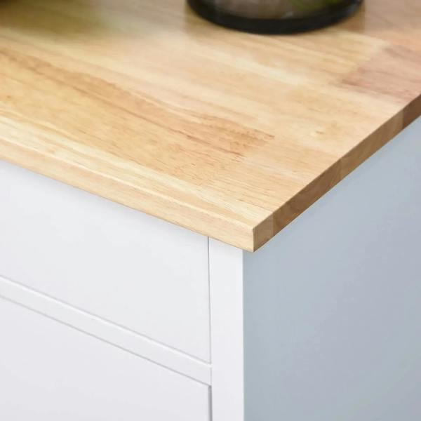 Light wood tabletop corner on a white kitchen trolley cabinet