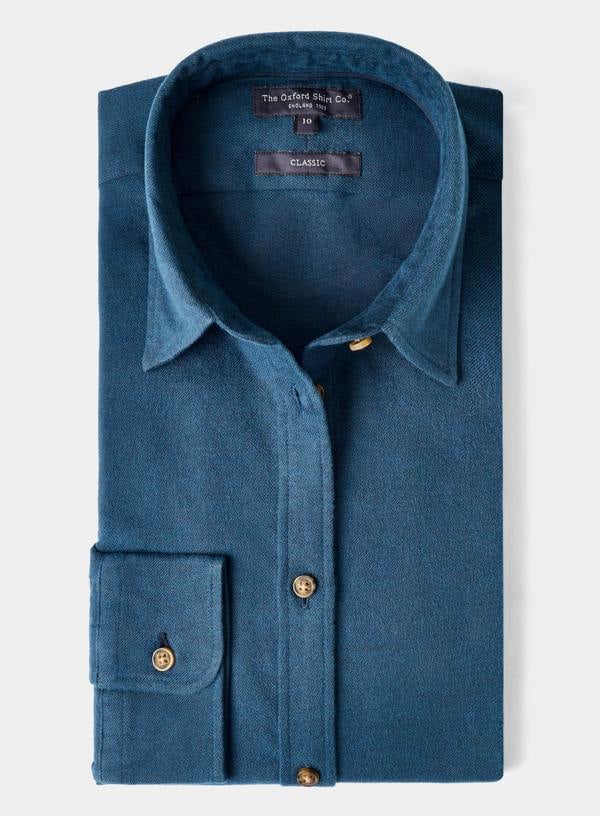 Folded blue shirt with gold buttons on a white background