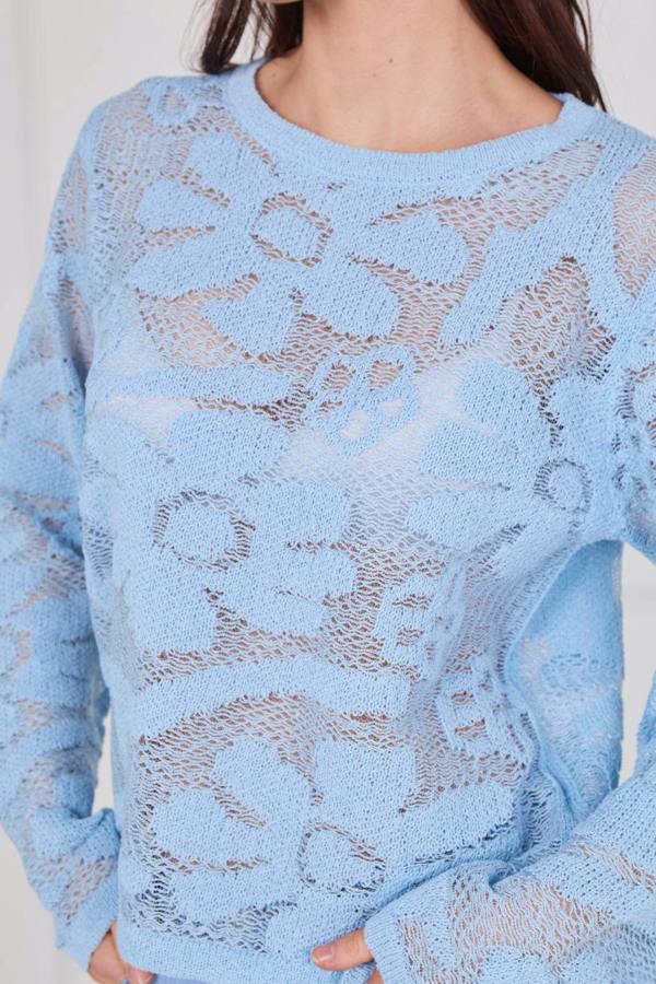 Model wearing a long sleeve crochet top with an open-knit pattern, styled with high-waisted jeans, featuring a relaxed fit and lightweight texture for casual everyday wear.