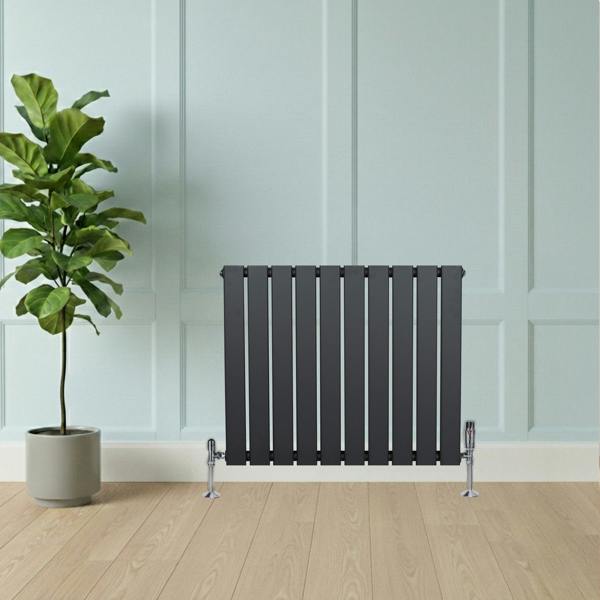 Flat single column radiator in anthracite grey, featuring a sleek design with vertical slats, positioned against a light blue wall and wooden floor