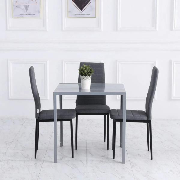 Grey square dining table with glass top and metal legs with four chairs