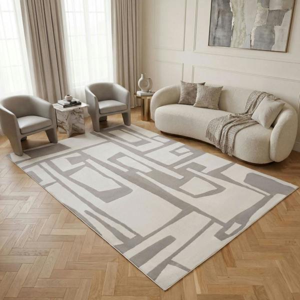 Living room with a geometric patterned rug, sofa, and chairs.