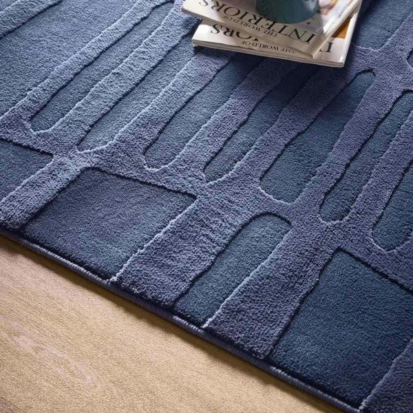 Blue textured rug with a pattern on a wooden floor
