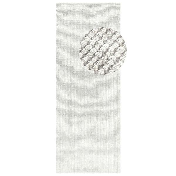 Textured white rug with a circular pattern on a plain background