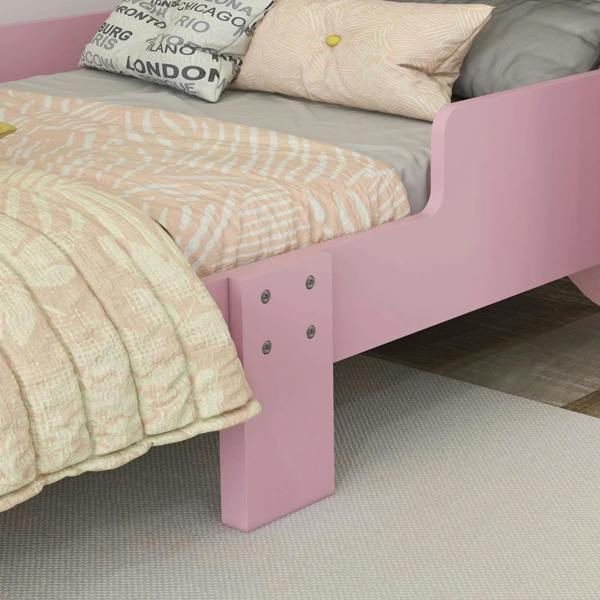 Close-up of pink toddler bed frame legs and front panel with slats, cat bed style.