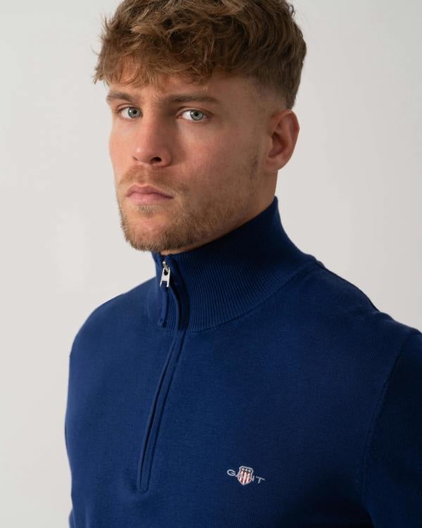 Model wearing GANT Mens Classic Cotton Half Zip Jumper in 432 Rich Navy - Logo detail