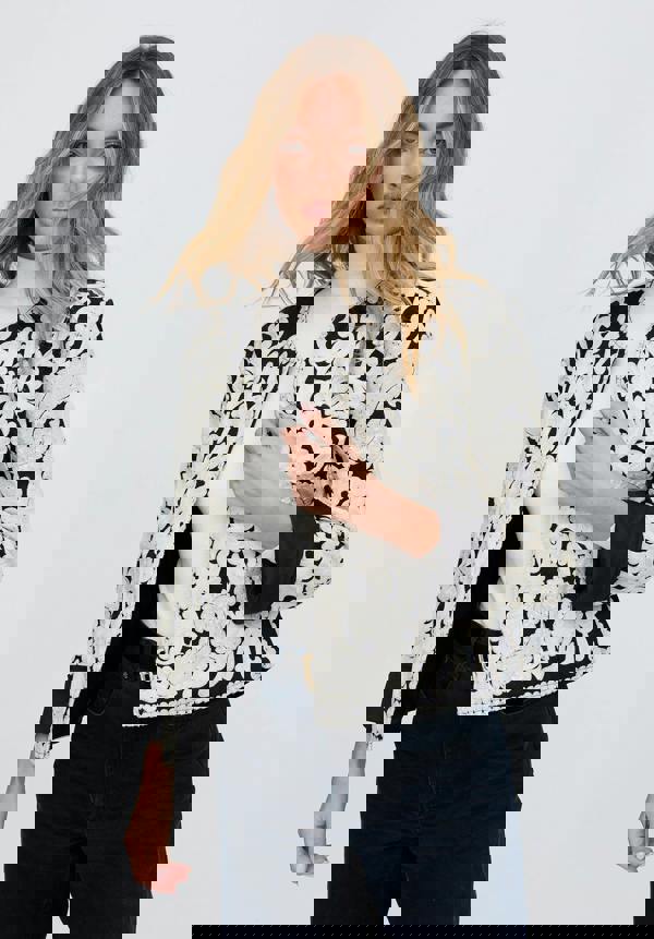 Woman wearing a black and white lace jacket on a white background