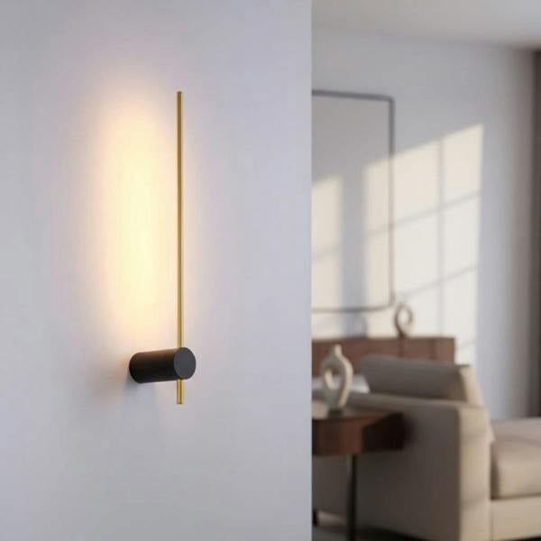 Black and gold interior LED wall sconce shown on a grey wall in a modern home