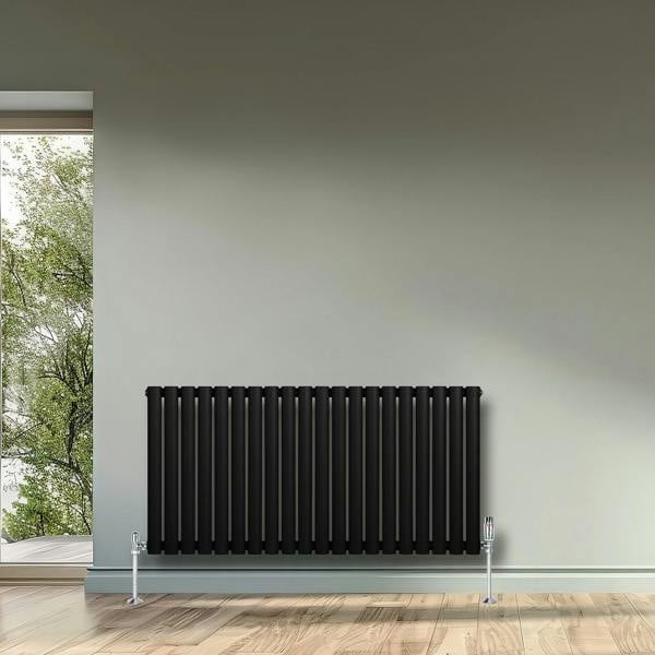 Sleek black oval single column radiator, 600 x 1200mm, mounted on a light gray wall, complementing a modern interior design