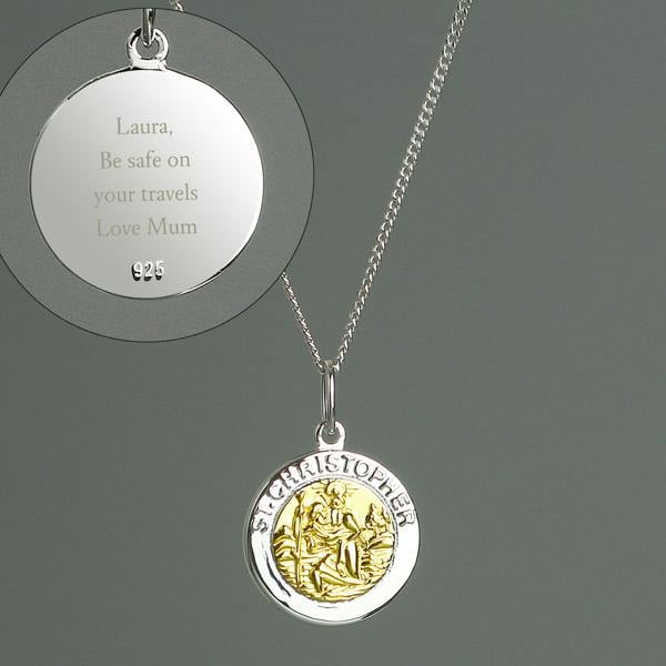 A sterling silver and 9ct gold-plated St. Christopher pendant necklace by Abode Home & Gifts on an 18-inch chain against a grey background. An inset circle highlights the engraved reverse side with the message "Laura, Be safe on your travels Love Mum" and a 925 sterling silver hallmark.
