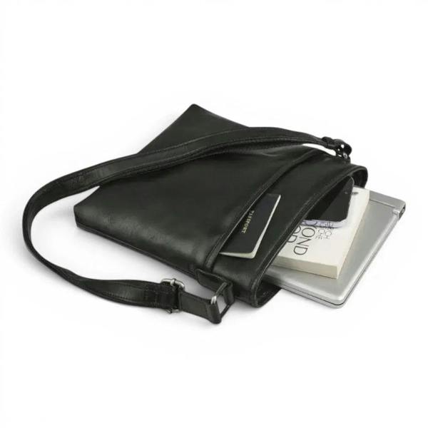 A black leather crossbody bag with a long strap, shown open with a tablet, book, and card partially visible inside, on a clean white background.