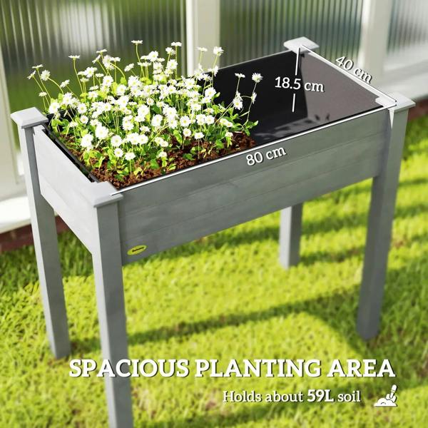 Dark grey elevated planter box with blooming white flowers and open planting bed.
