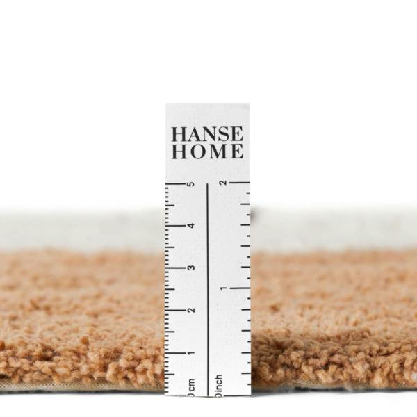 Close-up of a carpet sample with a ruler displaying 'HANSE HOME' branding.