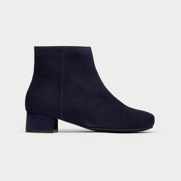 Navy blue ankle boot on a light gray background
