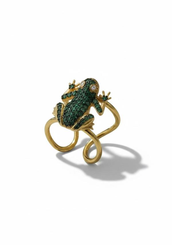 Gold frog-shaped ring with green gemstones on a white background