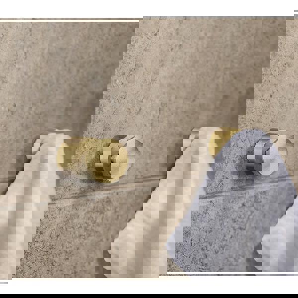 Pair of brushed brass towel hooks on bathroom wall