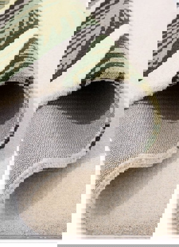 Close-up of Paradise Leaf hand-tufted wool rug showcasing cream and green leaf design with soft texture.